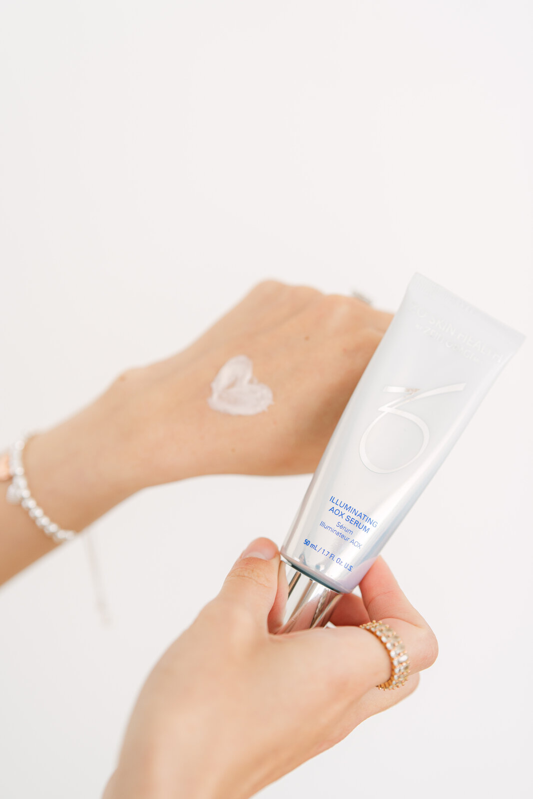 Applying ZO Skin Health illuminating eye serum